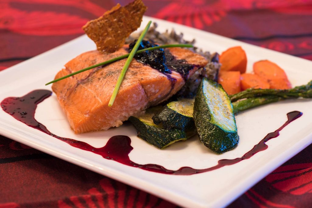 decadent salmon dinner with vegetables and berry sauce