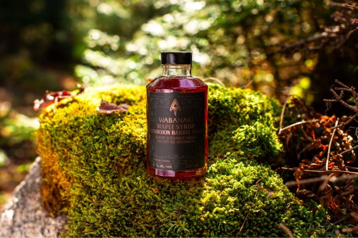 Wabanakim Maple syrup pictured outdoors on a mossy log